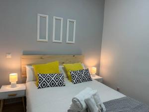 Un dormitorio con una cama blanca con almohadas amarillas y negras en Market Martinez De La Riva I, en Madrid