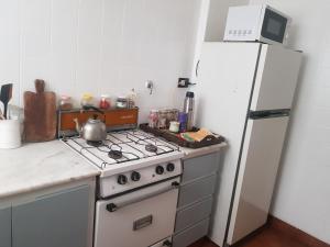 een keuken met een wit fornuis en een koelkast bij Departamento cerca de la playa in Mar del Plata