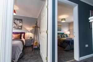 a bedroom with two beds and blue walls at Newly Renovated Modern House with FREE Parking in Nottingham