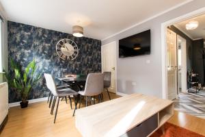 a dining room with a table and a clock on the wall at Newly Renovated Modern House with FREE Parking in Nottingham