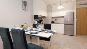 a kitchen with a table with plates of food on it at Apartament Kasprowicza 20 A z garażen in Kołobrzeg