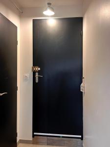 a black door with a sign on it in a room at Le Cosy, charmant studio in Feyzin