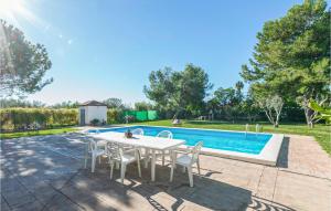 - une table et des chaises blanches à côté de la piscine dans l'établissement 3 Bedroom Awesome Home In Carmona, à Carmona