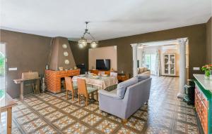 - un salon avec une table, des chaises et une cheminée dans l'établissement 3 Bedroom Awesome Home In Carmona, à Carmona