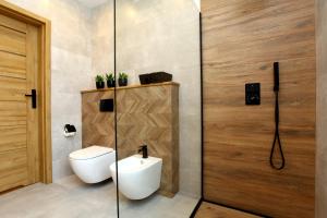 un bagno con wc e porta a vetri di Villa Park 7 a Wapnica Altre 20 foto