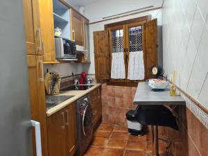 una pequeña cocina con armarios de madera y fregadero en Bulas 24, en Toledo