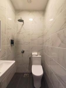 a bathroom with a toilet and a sink and a tub at Red's Hotel in Bintulu +49 photos