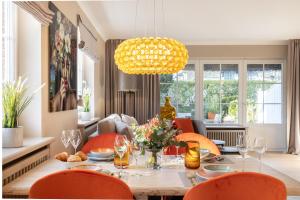 uma sala de jantar com uma mesa e cadeiras laranja em NEU! Ferienwohnung Kuestenchalet in Keitum auf Sylt em Keitum