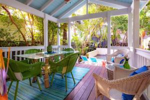 基韋斯特的住宿－Bahama House，一个带桌椅的屏蔽门廊