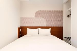 京都市にあるHop Inn Kyoto Shijo Omiyaの白いベッド1台(木製ヘッドボード付)が備わるベッドルーム1室が備わります。
