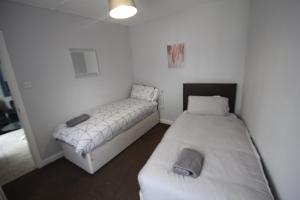 a room with two beds in a room at Rockingham House Uxbridge in Uxbridge