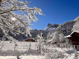 a winter scene with snow covered trees and a cabin at Wesley House in Kandersteg