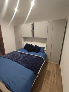 - une chambre avec un lit doté de draps et d'oreillers bleus dans l'établissement Camellia Apartments Ta' Xbiex, à Taʼ Xbiex