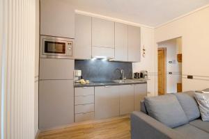 kuchnia z białymi szafkami i kanapą w obiekcie Alba Villa Nordica w Livigno