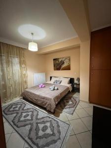 ein Schlafzimmer mit einem Bett mit rosa Blumen drauf in der Unterkunft Bakopoulos resort.Ενα όμορφο διαμέρισμα με τζάκι in Tríkala