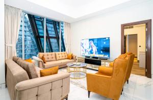 sala de estar con sofás y TV de pantalla plana. en New Arabian 2 Bedroom J One Tower Business Bay en Dubái