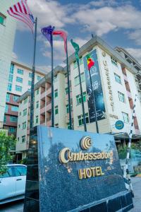 un cartello per un hotel di fronte a un edificio di Ambassador Hotel ad Addis Abeba
