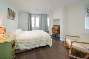 a bedroom with a bed and a desk and a chair at Flat 1, Medeira House in Seaview