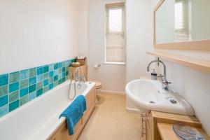 a bathroom with a bath tub and a sink at Flat 1, Medeira House in Seaview