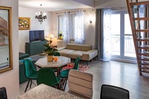 un soggiorno con divano, tavolo e sedie di Apartament Panoramiczny a Polanica-Zdrój