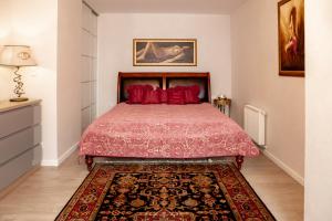 una camera da letto con un letto con cuscini rossi e un tappeto di Apartament Panoramiczny a Polanica-Zdrój