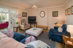 a living room with blue couches and a television at The Green House - 12 Kings Close in Bembridge