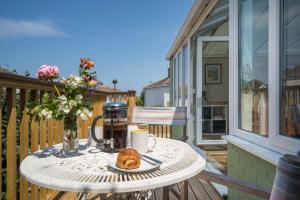 a table with a coffee maker and a croissant on a balcony at The Green House - 12 Kings Close in Bembridge