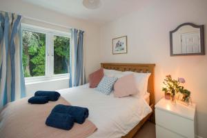 Un dormitorio con una cama con dos toallas azules encima. en The Green House, en Bembridge