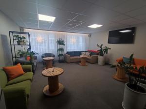 a living room with couches and a table and a tv at Jantar Economy in Szczecin