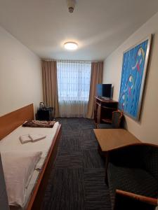 una camera d'albergo con letto, tavolo e scrivania di Jantar Economy a Stettino