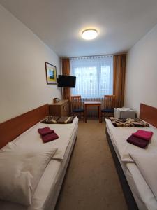 um quarto de hotel com duas camas e uma mesa em Jantar Economy em Szczecin