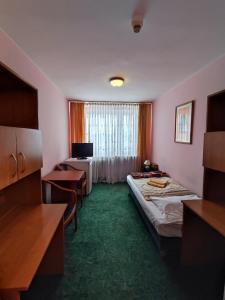 a hotel room with a bed and a desk at Jantar Economy in Szczecin +48 photos