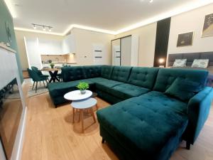 een woonkamer met een groene bank en een tafel bij Holi Resort in Serock