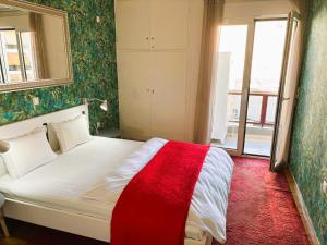 ein Schlafzimmer mit einem Bett mit einer roten Decke darauf in der Unterkunft Apartament Athina in Athen