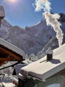 a house with snow on the roof with a mountain at Alpine Chalet in Kandersteg