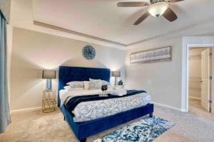 Schlafzimmer mit einem blauen Bett und einem Deckenventilator in der Unterkunft SOOTHING VILLA: Spacious house, nice neighborhood in Mill Creek