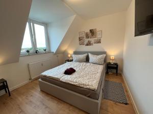 a bedroom with a bed and two windows at Wohnperle*WindbergBlick*ruhig in Wilsdruff