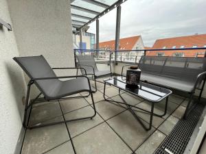 - Balcón con sillas, mesa y banco en Wohnperle*WindbergBlick*ruhig, en Wilsdruff