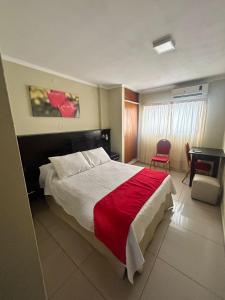 Habitación de hotel con cama y escritorio en Hotel Everest en Córdoba