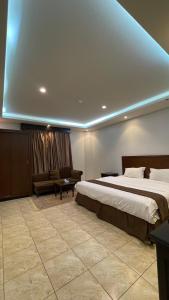 1 dormitorio grande con 1 cama grande y 1 sofá en فندق بوابة العالية, en Medina