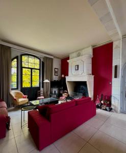 - un salon avec un canapé rouge et une cheminée dans l'établissement Maison Etcheverria, à Argelès-Gazost