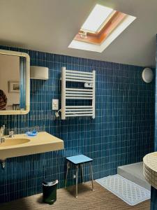 een badkamer met blauwe betegelde muren en een wastafel bij Maison Etcheverria in Argelès-Gazost