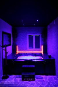 Cette chambre violette dispose d'une baignoire éclairée. dans l'établissement L'appar-T loft avec Spa privatif et jardin, à Gières