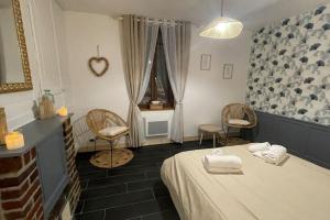 um quarto com uma cama, 2 cadeiras e uma janela em Gîte « Le Querqus » - 6 voyageurs em Allouville-Bellefosse