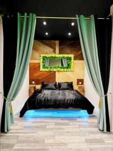 a bedroom with a black bed and a mirror at L'appar-T loft avec Spa privatif et jardin in Gières
