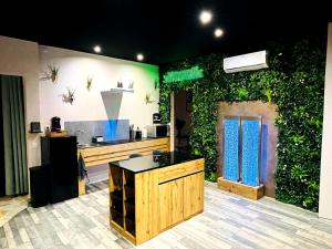 a room with an ivy covered wall with a kitchen at L'appar-T loft avec Spa privatif et jardin in Gières