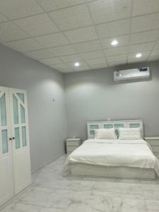 a bedroom with a large bed in a white room at شالية ألأمراء 