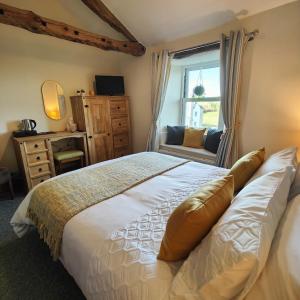 a bedroom with a large bed and a window at The Herdwick Inn in Penruddock