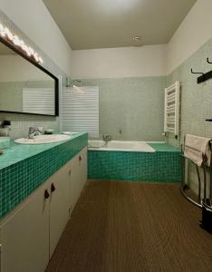La salle de bains est pourvue de 2 lavabos et d'une baignoire. dans l'établissement Maison Etcheverria, à Argelès-Gazost