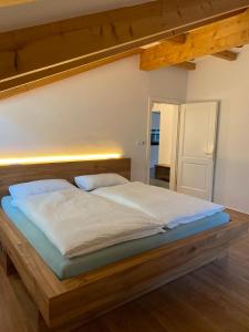 uma cama grande com uma estrutura de madeira num quarto em Apartment Obstplatz - Free Parking included em Bolzano